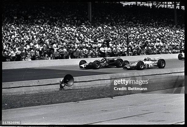 Early in the 500-mile Indianapolis Speedway classic here, May 31, Jimmy Clark shoots ahead of pole position holder A.J. Foyt to take the lead. The...