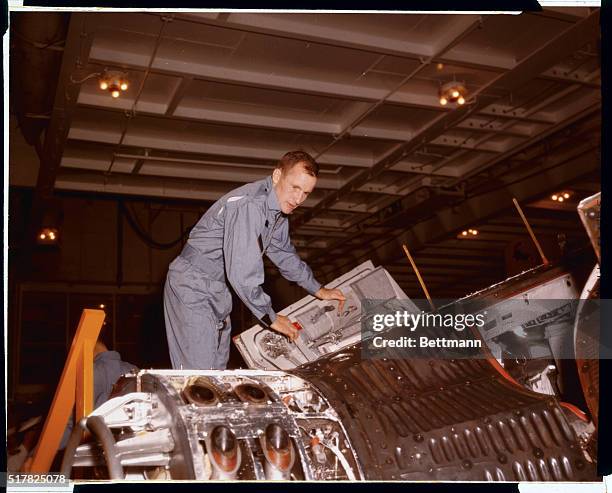 Astronaut Ed White looks over Gemini IV capsule which carried him and Jim McDivitt on four day space flight.