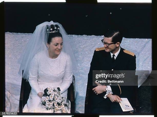 Princess Margriet of Holland and Pieter Van Vollenhoven smile at each other during their wedding ceremony.