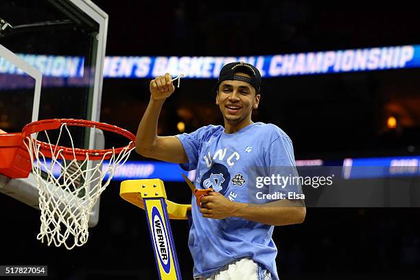 Marcus Paige of the North Carolina Tar Heels celebrates by cutting down the net after defeating the Notre Dame Fighting Irish with a score of 74 to...