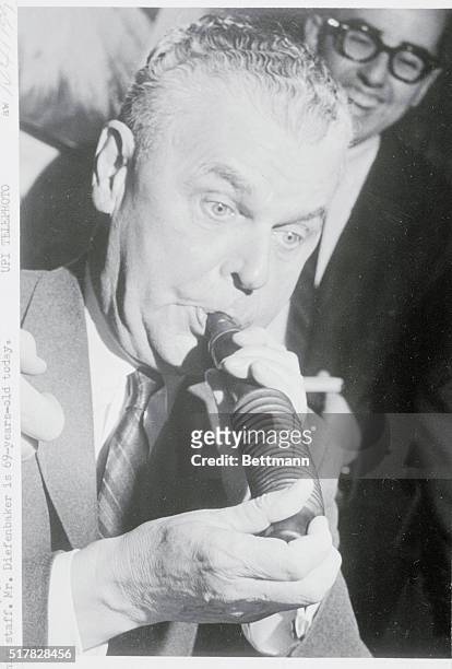 Ottawa, Ont.: Opposition Leader John Diefenbaker tries out a new duck caller, one of the many presents which he received at an impromptu birthday...