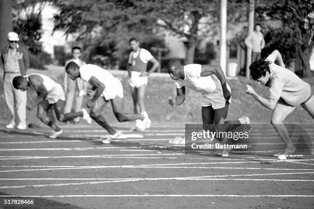 Sprinter Bob Hayes practices starts with New Zealander Doreen Porter, October 1st, in Olympic Village here as the track teams got down to hard...