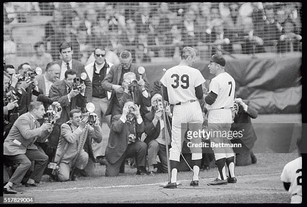 Facing a battery of photographers, Yankee pitcher Steve Hamilton presents a plaque to Mickey Mantle commemorating his 500th homer , in pregame...