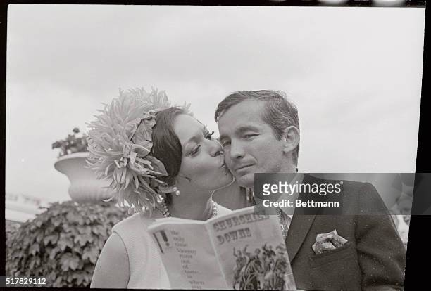 Kiss for luck in selecting the Kentucky Derby winner in the 94th running of the race at Churchill Downs is given to Bill Shoemaker by his wife....