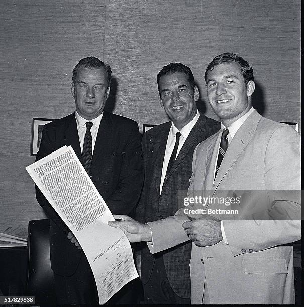 Gary Beban, the UCLA All-American and 1967 Heisman Trophy winner, holds a contract- which he later signed- in the office of the Washington Redskins...