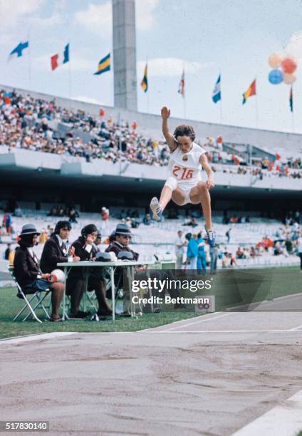 Mexico City, Mexico: Rumania's Viorica Viscopoleanu, one knee bandaged, leaps 22 feet, 4 1/2 inches to win an Olympic gold medal and better the...