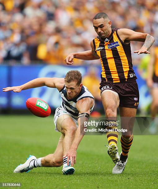 Shaun Burgoyne of the Hawks kicks the ball off the ground dangerously near the head of Joel Selwood of the Cats during the round one AFL match...