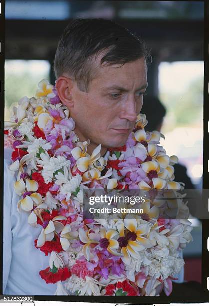 Yevgeny Yevtushenko- Russian poet with flowers around his neck. Place unknown