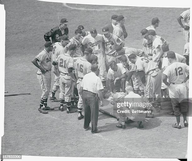 Both Milwaukee and Dodgers players stand over Braves' player Joe Adcock who was hit by a pitched ball thrown by Clem Labine in the fourth inning of...