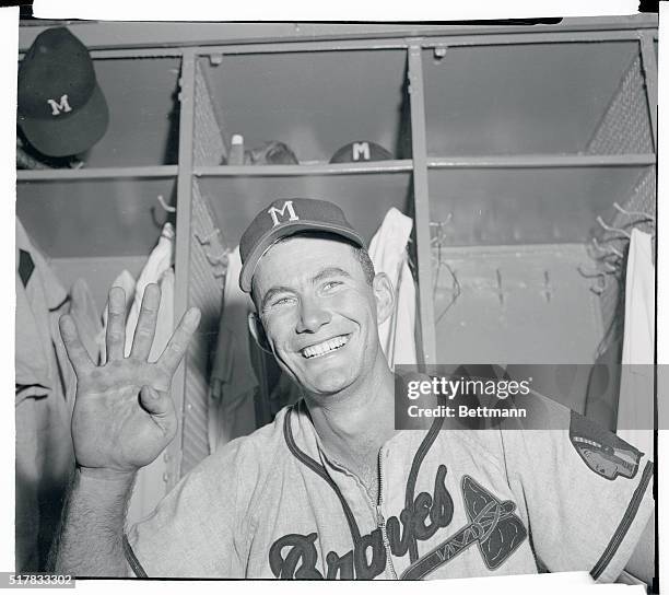 Joe Adcock of the Braves smiles triumphantly in the dressing room after tying a major league record by belting four home runs in the game with the...