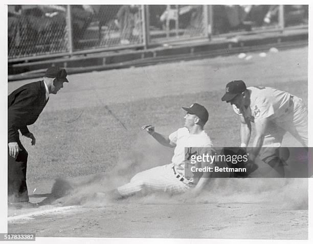 Yankee outfielder Irv Noren, advancing from first to third on Carey's single, beats the peg to Al Rosen of the Indians, who tries for the tag. Ump....
