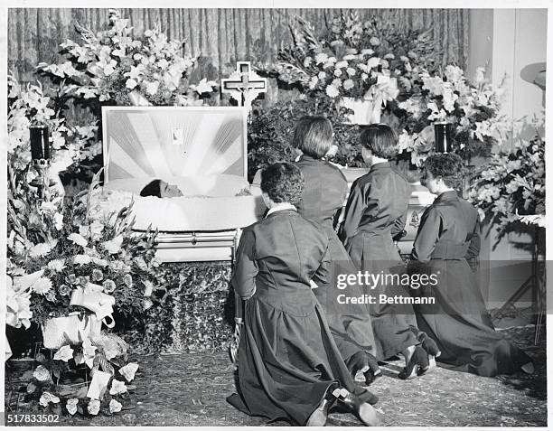 Final Farewell to Emilie. Callander, Ontario: The four surviving Dionne quintuplets are shown kneeling in prayer beside the casket of their...