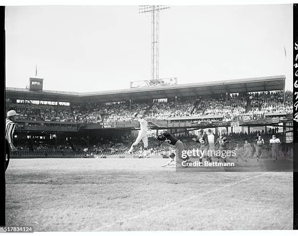 Charlie Conerly of the New York Giants is up in the air about to throw the first of four touchdown passes that paced the Giants to a 51-21 victory...