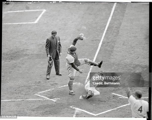 Junior Gilliam, Dodgers second baseman is safe at home on Peewee Reese's double in the first inning action of Dodgers-Cincinnati game at Ebbets Field...