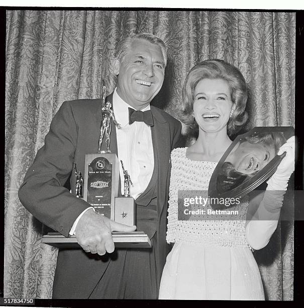 Cary Grant and Angie Dickinson flash big smiles as they hold awards presented to them as "Star of the Year" and "Most Exciting New Star,"...