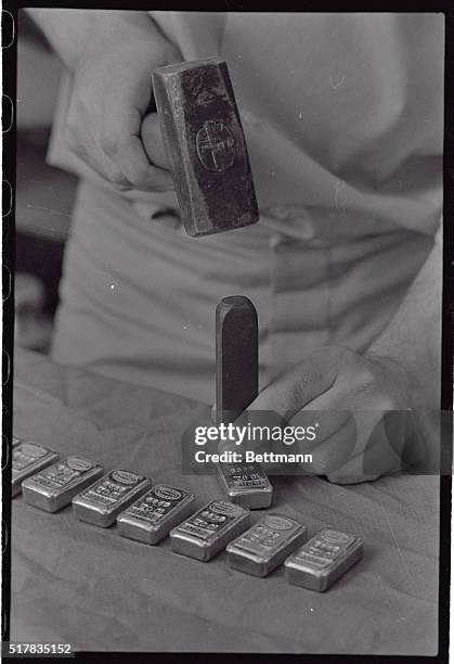 Name, weight and lot number are stamped on 10-ounce gold bars by hand at the Johnson Matthey Ltd. Plant at Brampton recently. The Bache gold bar can...