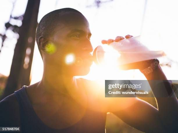 close up shot with lens flare of afro-american athlete - running refreshment stock pictures, royalty-free photos & images