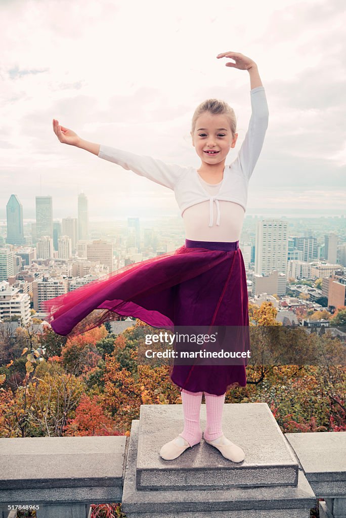 Little kid, big dreams; dancing in front of cityscape.