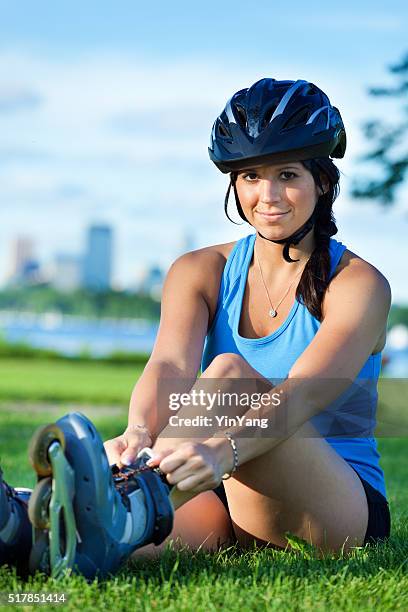 healthy woman in-line skater resting in an urban city park - skaten stockfoto's en -beelden
