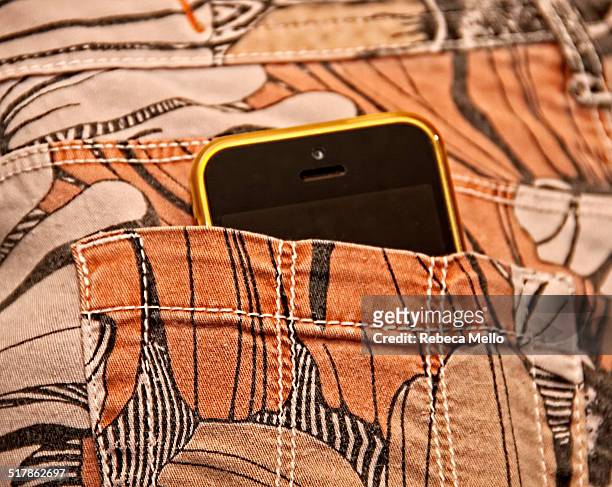 Yellow IPhone 5C in back pocket of stamped trousers