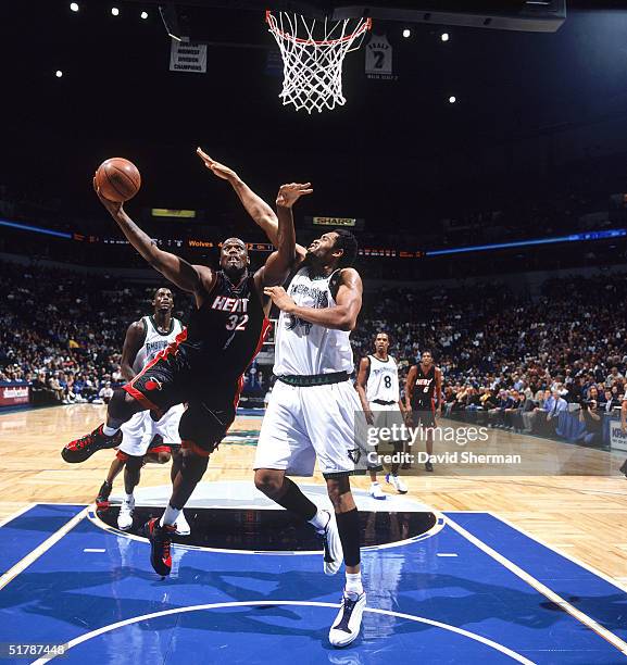 Shaquille O'Neal of the Miami Heat shoots against Michael Olowokandi of the Minnesota Timberwolves during the game at Target Center on November 16,...