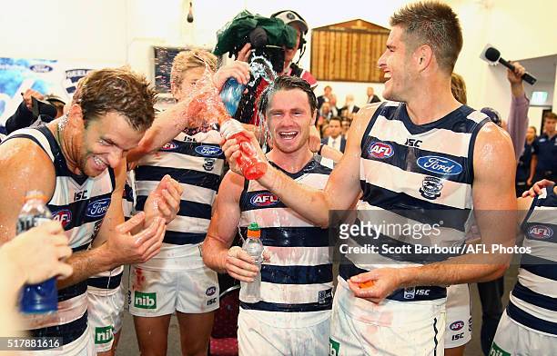 Patrick Dangerfield and Lachie Henderson of the Geelong Cats sing the team song in the changing rooms after winning the round one AFL match between...