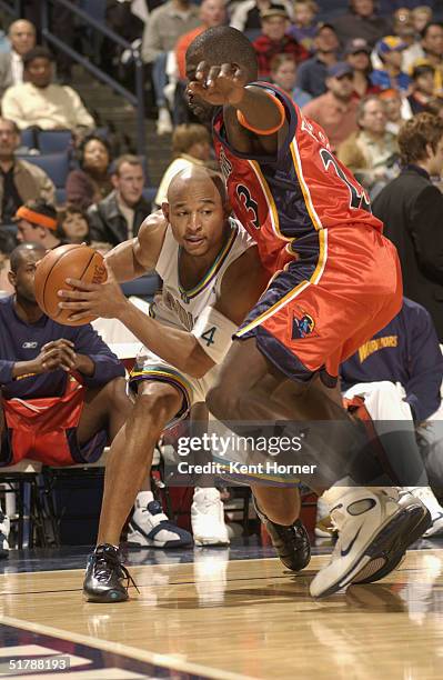 David Wesley of the New Orleans Hornets drives past Jason Richardson of the Golden State Warriors at the Arena in Oakland on November 23, 2004 in...