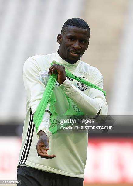 German defender Antonio Ruediger puts on his training shirt during the final team training session on the eve of the friendly football match Germany...