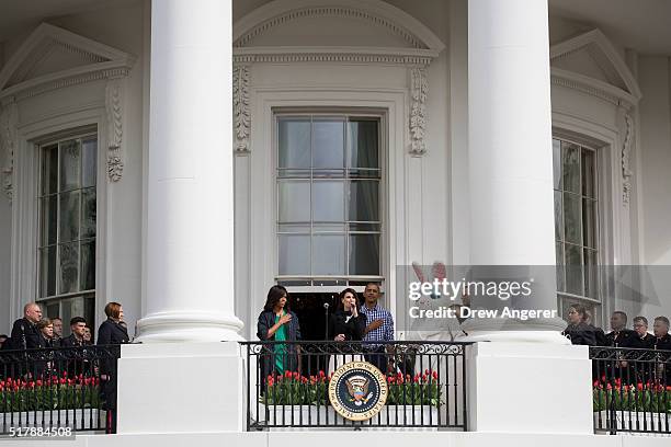 Flanked by first lady Michelle Obama and President Barack Obama, Idina Menzel sings the National Anthem during the annual White House Easter Egg Roll...