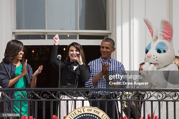 Flanked by first lady Michelle Obama and President Barack Obama, Idina Menzel sings the National Anthem during the annual White House Easter Egg Roll...