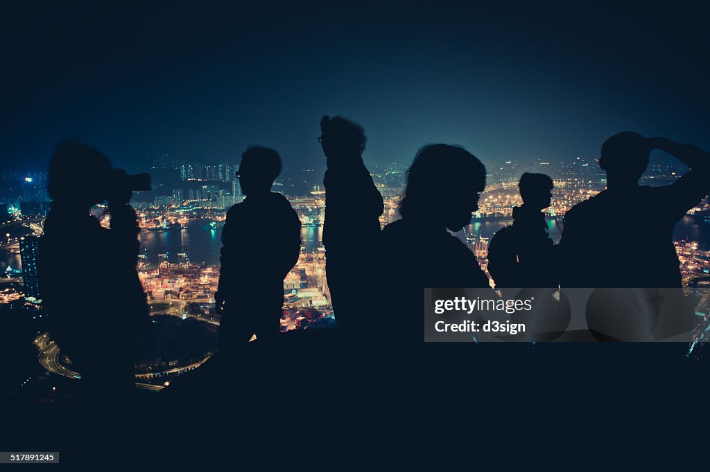 Silhouette of hikers on mountain top at night time