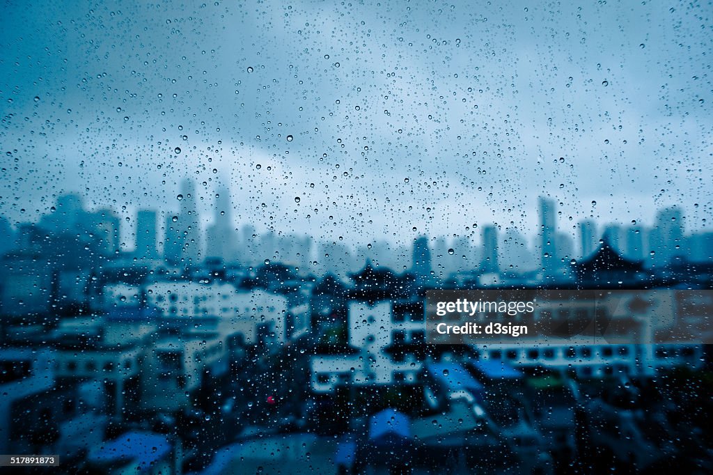 Raindrops on window glass with rainy Shanghai city