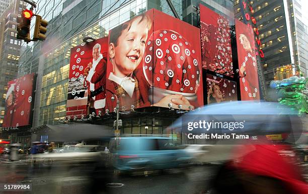 Pedestrians are blurred as they walk past a holiday advertisement for Target stores in Times Square November 24, 2004 in New York City. Retailers are...