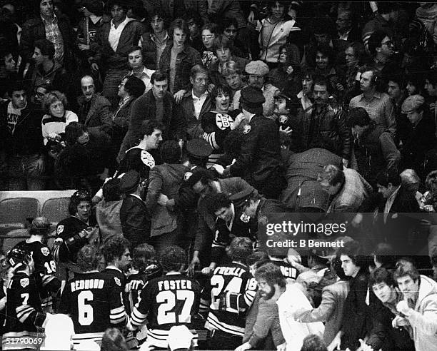 American professional ice hockey player and later coach and general manager Mike Milbury of the Boston Bruins is restrained by police after charging...