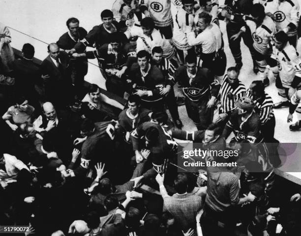 Members of the Montreal Canadiens professional ice hockey team under the guidance and leadership of captain Pete Mahovlich charge into the stands at...