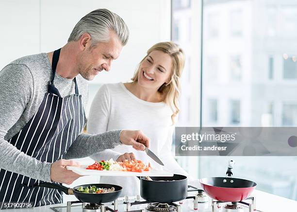 カップルの自宅で調理 - middle aged couple cooking ストックフォトと画像