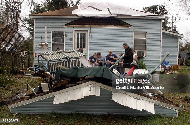 The Chisolm family sits on the front porch of their damaged home on November 24, 2004 in Olla, Louisiana. Tornados swept across central Louisiana...