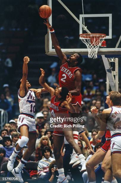 Moses Malone of the Philadelphia 76ers blocks a shot against the New Jersey Nets during a 1982 NBA game at the Brendan Byrne Arena in East...