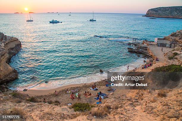 sunset in cala compte beach with people in ibiza. - ibiza town stock pictures, royalty-free photos & images