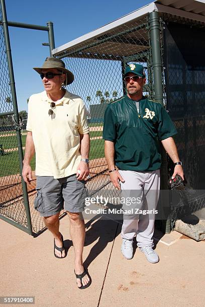 Executive Vice President of Baseball Operations Billy Beane of the Oakland Athletics stands on the field with Bench Coach Mark Kotsay during a spring...