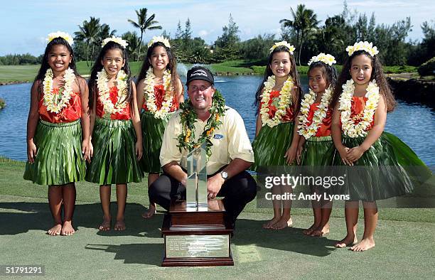 Phil Mickelson is pictured with the winner's trophy and six Keiki hula dancers after winning the 22nd PGA Grand Slam of Golf on November 24, 2004 at...