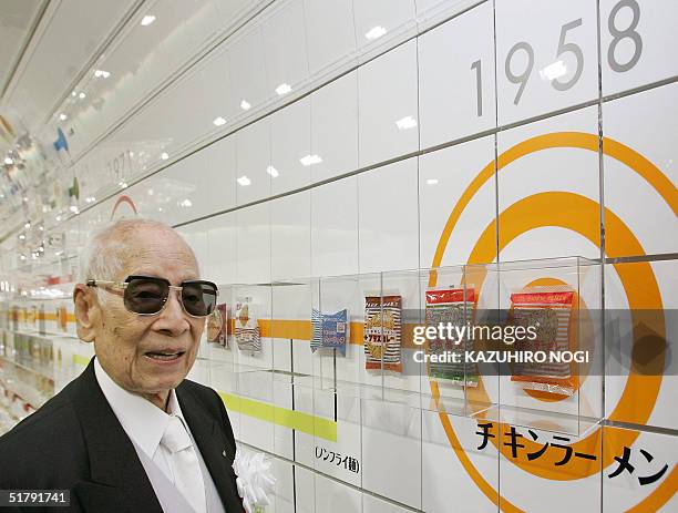 Momofuku Ando founder of Japan's Nissin Food Products Co., poses next to a package of company's historic first bag of chicken ramen which was...