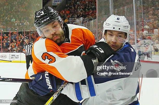 Radko Gudas of the Philadelphia Flyers hits Alexander Burmistrov of the Winnipeg Jets during the first period at the Wells Fargo Center on March 28,...