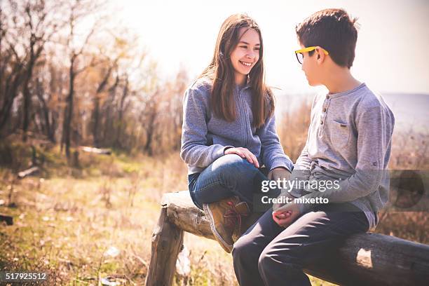 día en la naturaleza con amigos - boy and girl talking fotografías e imágenes de stock