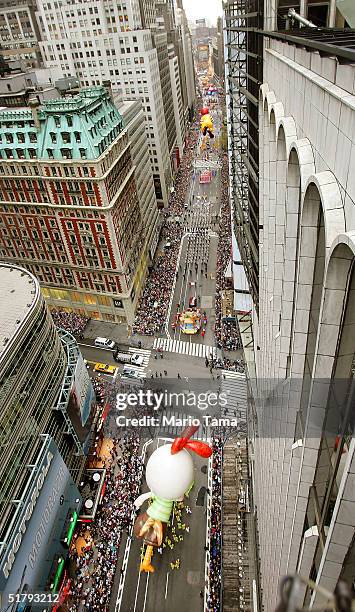 Onlookers watch as giant balloons pass down Broadway during the 78th Annual Macy's Thanksgiving Day Parade November 25, 2004 in New York City....