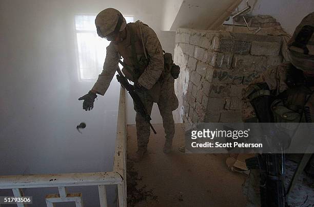 Marine drops a grenade down a stairwell to clear a lower floor as US Marines of the 1st Light Armored Reconnaissance company, as part of 1st...