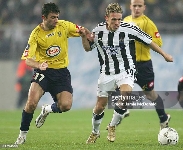 Craig Bellamy of Newcastle holds off Romain Pitau of Sochaux during the UEFA Cup Group D match between FC Sochaux and Newcastle United at the Stade...