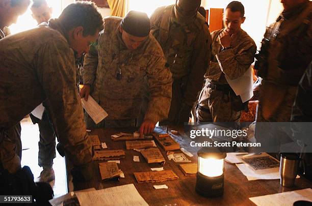 Captain Gil Juarez takes his platoon leaders through a "rock walk" rehearsal of the operation, using meal boxes and sugar sachets for the town model,...