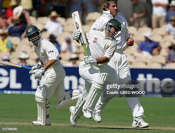 Australian batsman Ricky Ponting , watched by teammate Justin Langer , runs around New Zealand bowler Jacob Oram , during the second session on day...