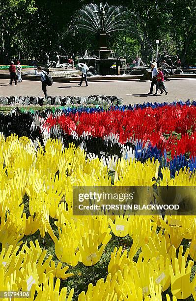 Passers-by wander past the "Sea of Hands" symbolising reconciliation between Aborigines and white Australians in Sydney's Hyde Park, 26 November...